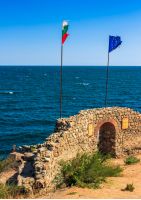 SOZOPOL, BULGARIA - SEPTEMBER 08, 2013: Northen tower with entrance to the fortress of sozopol. European and Bulgarian flag wave abow the Black Sea shore