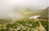 Steep slope on rocky hillside over balea lake in fog. mystic weather in romanian mountains