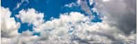 amazing cloud formations on a dark blue sky. beautiful side lit cloudscape panorama in summer