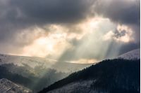 beams of light over the mountains. gorgeous scenery on a cloudy day in winter