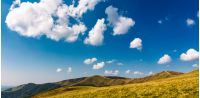 beautiful cloud formations on a deep blue sky. lovely panoramic landscape of mountain ridge