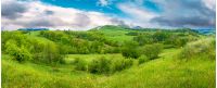 beautiful countryside panorama in springtime. grassy hills and meadows. trees with green foliage on hillsides. mountain top in the distance. wonderful nature scenery of Carpathians