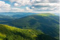 beautiful landscape of carpathian mountains. grassy alpine meadows, deep valleys. wonderful sunny weather at sunset in summer. fluffy clouds on the blue sky