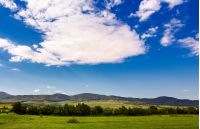 beautiful summer sky over the mountainous area. lovely countryside with forested hills and fields
