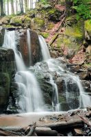 beautiful two cascaded waterfall among the forest. wonderful nature scenery in spring or summer. fallen foliage on the ground. huge boulders. refreshing stream