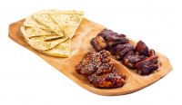 beer snack on the wooden plate. grilled pork ribs and chicken wings with italian pita bread chips