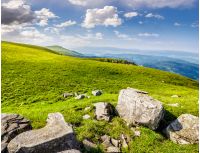 white sharp boulders on the hillside meadow with green grass in high Crapathian mountains