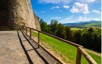 castle wall and railing on a hill. view in to the beautiful mountainous landscape 