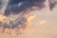cumulus clouds on the sky blown by the wind. warm scenery. cloudy weather meteorology background in orange glow. evening mood