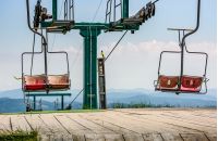 empty ski elevator with red chairs on top of a hill Gymba. Carpathian mountain ridge Borzhava, Ukraine. Lovely mountain landscape with clear sky
