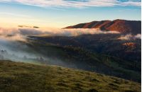 fog rolling over the hills at sunrise. stunning countryside autumnal background