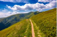 footpath through grassy mountain ridge. beautiful summer landscape under gorgeous sky with clouds