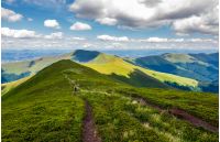 footpath through mountain ridge in summer. group of tourists following the path. lovely landscape and travel concept