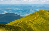 footpath through mountain ridge with grassy slopes. beautiful summer nature scenery