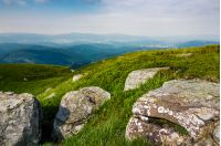 grassy slope of a hill with huge boulders. beautiful landscape of Polonina Runa ridge on a cloudy summer day
