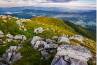 huge rocky formations on the grassy hills. beautiful mountain landscape in late summer on a cloudy day. location Runa mountain, Ukraine