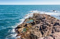 landscape of sea coast with rock in summer. seascape background for travel. textured coastline with blue sky above horizon