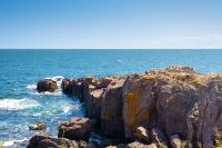 landscape with sea and coast with rock. vacation season with beautiful seascape in summer. travel background with water splash on stone