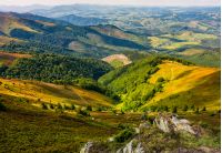 landscape with grassy meadow and giant boulders on the edge of a slope in Carpathian mountain ridge. beautiful and sunny late summer day in mountains