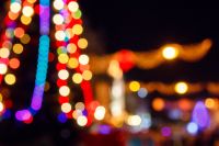 outdoor scene defocused christmas tree. festive abstract background of street for new year with bokeh effect. colorful backdrop with shimmering garlands for winter holidays