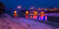 panorama of bridge through the river Uzh at night. beautiful cityscape of old european town Uzhgorod in winter