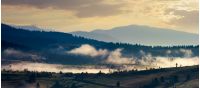 panorama of countryside in the morning. beautiful landscape in mountains with fog rising above the valley and hill