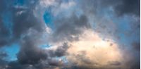 panorama of gorgeous cloudscape at dusk. heavy autumn clouds lit by the last rays of sun