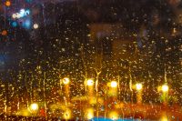 rain behind the hotel window. raindrop on the glass at night. blurred background abstract wallpaper