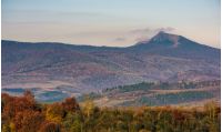 ridge with high peak above hills with forest. lovely mountainous background in late autumn