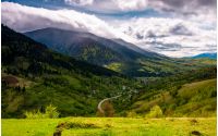 road through the village in valley of Carpathians. lovely springtime scenery in mountains of Synevyr National park