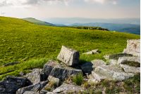 rocks on grassy meadow on top of a hill. beautiful summer scenery in mountains