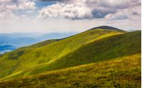 rolling hillsides of Carpathian mountain ridge. Beautiful nature background with cloudy sky