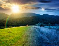 rural field on the hill. time change concept. view in to the valley at twilight. sun and moon over countryside mountain landscape. alpine pasture near forested hills. uncertainty and trust issues