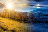 rural landscape on autumn equinox. day and night time change concept. trees on rolling hills. scenic view of mountainous countryside in fall season with sun and moon at twilight