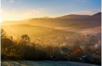 spectacular foggy sunrise in mountainous countryside. gorgeous autumnal landscape with village in mountains in fine weather