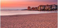 SOZOPOL, BULGARIA - SEPTEMBER 11, 2013: sunrise on sandy city beach in mellow season. Beautiful and warm weather on the shores of Black sea.