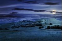 three hills in summer landscape at night in full moon light. beautiful countryside scenery.  tilt-shift and motion blur effect applied.