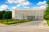 uzhhorod, ukraine - 06 may, 2017: government building of zakarpattia state administration. czechoslovakia architecture and cobblestone street of transcarpathia capital in evening light. narodna square