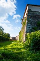 uzhhorod, ukraine - 08 aug 2012: grass in the old castle moat on a sunny afternoon. legendary landmark of transcarpathia under blue sky. medieval stronghold vertical travel background