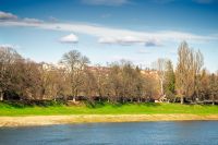uzhhorod, ukraine - 14 mar 2016: river uzh on a sunny weather. ukrainian city embankment in spring. urban landscape of eastern europe with part of masaryk bridge 
