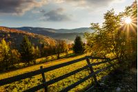 wooden fence in rural area at autumn sunrise. beautiful scenery in mountains