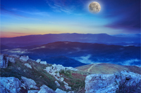 night mountain landscape with moon. valley with stones on the hillside. forest on the mountain under the beam of light falls on a clearing at the top of the hill.